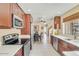 Well-lit kitchen with stainless appliances, wood cabinetry, and an open layout leading to the dining area at 1633 E Lakeside Dr # 139, Gilbert, AZ 85234