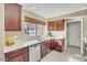 Charming kitchen view with wood cabinets, stainless steel dishwasher, and a bright window overlooking the backyard at 1633 E Lakeside Dr # 139, Gilbert, AZ 85234