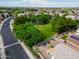 This aerial shot showcases the neighborhood park, mature trees, and sidewalks for evening strolls at 16861 W Ironwood St, Surprise, AZ 85388