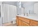 Well lit bathroom with a light wood vanity, a large mirror, and a shower with a white curtain at 16861 W Ironwood St, Surprise, AZ 85388