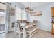 Cozy dining area with elegant lighting, white table and bench, and sliding glass door at 16861 W Ironwood St, Surprise, AZ 85388