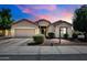 The exterior of the home, featuring a well-maintained yard and neutral-colored facade under a beautiful dusk sky at 16861 W Ironwood St, Surprise, AZ 85388