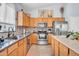 Kitchen featuring stainless steel appliances, wood cabinets, tile backsplash, and spacious countertop at 16861 W Ironwood St, Surprise, AZ 85388
