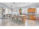 Open kitchen with island seating, stainless appliances, and tile flooring, seamlessly connecting to dining area at 16861 W Ironwood St, Surprise, AZ 85388