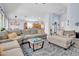 Open-concept living room with comfortable sectional and direct access to kitchen and foyer at 16861 W Ironwood St, Surprise, AZ 85388