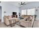 Spacious living room with light blue walls, tile floors, comfortable seating, and a ceiling fan at 16861 W Ironwood St, Surprise, AZ 85388