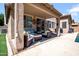 Covered patio with wicker furniture, stylish cushions, and sliding glass doors to the interior at 16861 W Ironwood St, Surprise, AZ 85388
