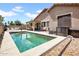 Backyard view with an in-ground pool, a covered patio with outdoor seating, and well kept landscaping at 16861 W Ironwood St, Surprise, AZ 85388