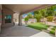 Charming covered patio leading to a lush backyard with a pristine pool, mature trees, and well-manicured artificial turf at 2018 E Avenida Del Sol --, Phoenix, AZ 85024