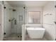 Modern bathroom featuring a freestanding tub and a tiled shower with gold fixtures and glass doors at 2018 E Avenida Del Sol --, Phoenix, AZ 85024