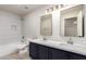 Modern bathroom featuring double sinks with dark cabinets and shower over tub at 2018 E Avenida Del Sol --, Phoenix, AZ 85024