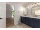 Bathroom with a double sink vanity with navy cabinets and views to the bedroom at 2018 E Avenida Del Sol --, Phoenix, AZ 85024