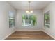 Bright dining room with wood floors, modern lighting, and large windows offering views of the backyard pool at 2018 E Avenida Del Sol --, Phoenix, AZ 85024