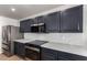 Close-up of a kitchen with stainless appliances, black cabinetry, and light countertops for a modern look at 2018 E Avenida Del Sol --, Phoenix, AZ 85024