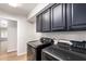 Well-organized laundry room featuring sleek, gray cabinets and state-of-the-art washer and dryer units at 2018 E Avenida Del Sol --, Phoenix, AZ 85024