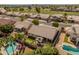 Neighborhood aerial view featuring lush landscaping, a putting green, a sparkling pool, and mature palm trees at 21335 N 64Th Ave, Glendale, AZ 85308