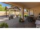 Outdoor covered patio with pavers, seating area, and view of the green yard at 21335 N 64Th Ave, Glendale, AZ 85308