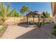 Backyard featuring a covered patio, pavers, turf, and desert landscaping at 21335 N 64Th Ave, Glendale, AZ 85308
