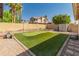 Beautiful backyard features a private putting green, lush landscaping, and a charming outdoor space for entertaining at 21335 N 64Th Ave, Glendale, AZ 85308