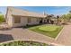 A home's backyard features a covered patio, putting green, and rock landscaping at 21335 N 64Th Ave, Glendale, AZ 85308