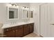 A bright bathroom featuring double sinks, modern lighting, and a doorway leading into the bedroom at 21335 N 64Th Ave, Glendale, AZ 85308