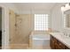 Bright bathroom with glass-enclosed shower, soaking tub, and ample natural light from the glass block window at 21335 N 64Th Ave, Glendale, AZ 85308