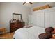 Cozy bedroom featuring a ceiling fan and a dresser, providing ample storage and organization at 21335 N 64Th Ave, Glendale, AZ 85308