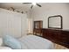 Relaxing bedroom space with sleek ceiling fan, dark wood dresser, and stylish decor pieces at 21335 N 64Th Ave, Glendale, AZ 85308