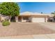 Charming single-story home featuring desert landscaping, a mature tree, and a convenient two-car garage at 21335 N 64Th Ave, Glendale, AZ 85308