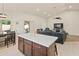 Bright open kitchen with island, marble countertops, and living area in the background at 21335 N 64Th Ave, Glendale, AZ 85308
