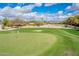 Scenic aerial view of a golf course, showcasing lush greens, a flag, and beautiful neighborhood homes at 22633 N Clubhouse Way, Scottsdale, AZ 85255