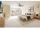 Bright main bedroom featuring neutral tones, plush carpet, sitting area, and a ceiling fan at 22633 N Clubhouse Way, Scottsdale, AZ 85255