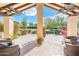 Relaxing covered patio with ceiling fans, comfortable seating, and a view of the landscaped backyard at 22633 N Clubhouse Way, Scottsdale, AZ 85255