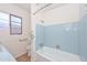 Bathroom features a blue tile bathtub, a bright window, and new hardware at 2419 W Shady Glen Ave, Phoenix, AZ 85023