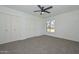 Bedroom features neutral carpet, a large window, and spacious closet at 2419 W Shady Glen Ave, Phoenix, AZ 85023