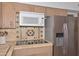 Updated kitchen showcasing stainless steel appliances, tile backsplash, wooden cabinetry, and functional countertop space at 2419 W Shady Glen Ave, Phoenix, AZ 85023