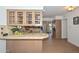 Kitchen featuring light-colored wood cabinets with glass doors, a breakfast bar, and hardwood floors at 2419 W Shady Glen Ave, Phoenix, AZ 85023