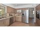 Cozy kitchen featuring stainless steel refrigerator and dishwasher, plus ample storage in the wooden cabinetry at 2419 W Shady Glen Ave, Phoenix, AZ 85023