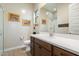 Bright bathroom featuring wood cabinets, neutral walls, and a glass door shower at 24280 N 164Th Dr, Surprise, AZ 85387
