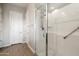 Bathroom featuring a glass-enclosed shower with tiled surround, grab bar, and a large white door at 24280 N 164Th Dr, Surprise, AZ 85387