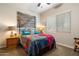 Bedroom featuring neutral walls, carpet flooring, a colorful bedspread, and a rustic wood accent piece above the bed at 24280 N 164Th Dr, Surprise, AZ 85387