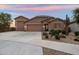 Beautiful single-story home featuring a three-car garage, desert landscaping, and a charming stone facade at 24280 N 164Th Dr, Surprise, AZ 85387