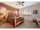 Cozy main bedroom featuring a log bed frame, ceiling fan, carpet flooring, and abundant natural light at 24280 N 164Th Dr, Surprise, AZ 85387