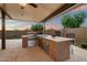 Outdoor kitchen with built-in grill, sink, and countertop space under covered patio at 24280 N 164Th Dr, Surprise, AZ 85387