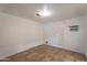 Clean bedroom with tile flooring, white walls, an A/C unit, and a door to the outside at 2445 W Yuma St, Phoenix, AZ 85009
