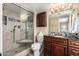 Bathroom showcasing a glass-enclosed shower, dark wood cabinetry and countertop space at 2524 S El Paradiso -- # 122, Mesa, AZ 85202