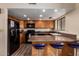 Bright kitchen with wood cabinets, black appliances, and breakfast bar with seating at 2524 S El Paradiso -- # 122, Mesa, AZ 85202