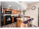 Well-lit kitchen featuring wood cabinetry, breakfast bar, and modern appliances at 2524 S El Paradiso -- # 122, Mesa, AZ 85202