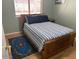 Bedroom with hardwood floors with a blue area rug, large window, and bedside table at 2649 N 85Th Ave, Phoenix, AZ 85037