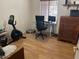Bedroom with hardwood floors, features a desk, workout bike, and ample natural light at 2649 N 85Th Ave, Phoenix, AZ 85037